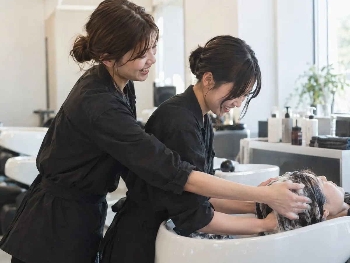 シャンプーを教えるアシスタント
